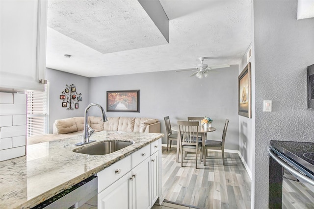 1505 Ward Rd Unit 232, Baytown, TX 77520 - kitchen featuring a sink, light stone counters, a textured ceiling, ceiling fan, and white cabinetry