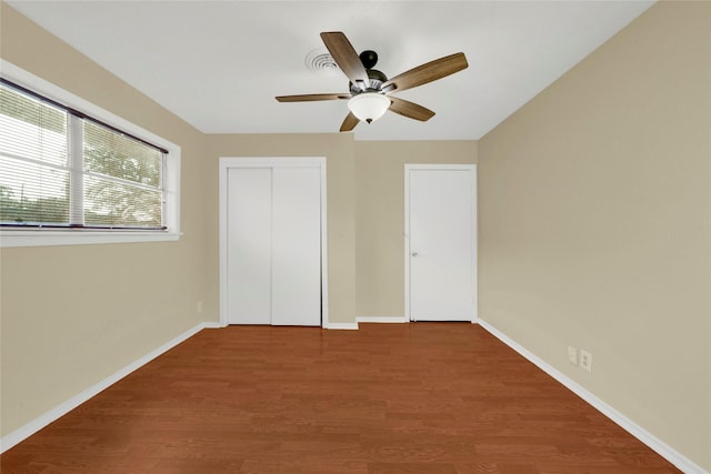 unfurnished bedroom with hardwood / wood-style flooring, ceiling fan, and a closet