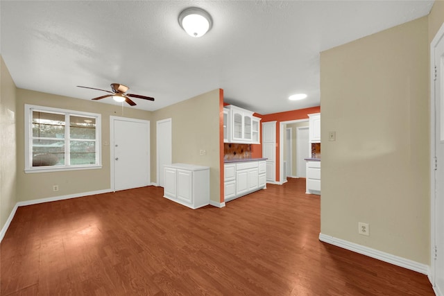 unfurnished living room with wood-type flooring and ceiling fan