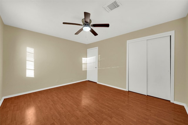 unfurnished bedroom featuring ceiling fan, hardwood / wood-style floors, and a closet