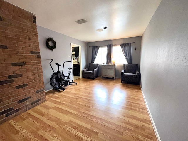 workout area with light hardwood / wood-style flooring