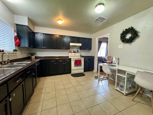 kitchen with light tile patterned floors, sink, a textured ceiling, and electric range