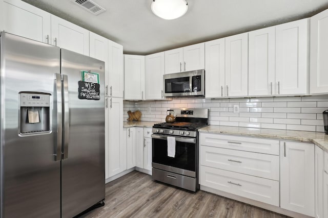 kitchen with white cabinetry, visible vents, and appliances with stainless steel finishes