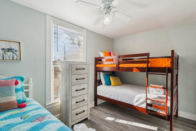 bedroom featuring a ceiling fan, baseboards, and wood finished floors