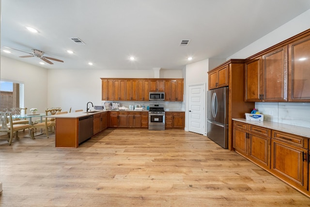 kitchen featuring sink, light hardwood / wood-style flooring, stainless steel appliances, and kitchen peninsula