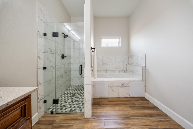 bathroom featuring vanity, hardwood / wood-style flooring, and plus walk in shower