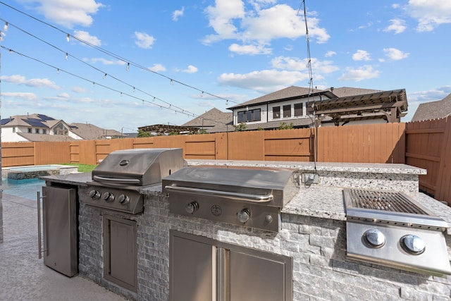 view of patio / terrace with an outdoor kitchen, a fenced backyard, and a grill