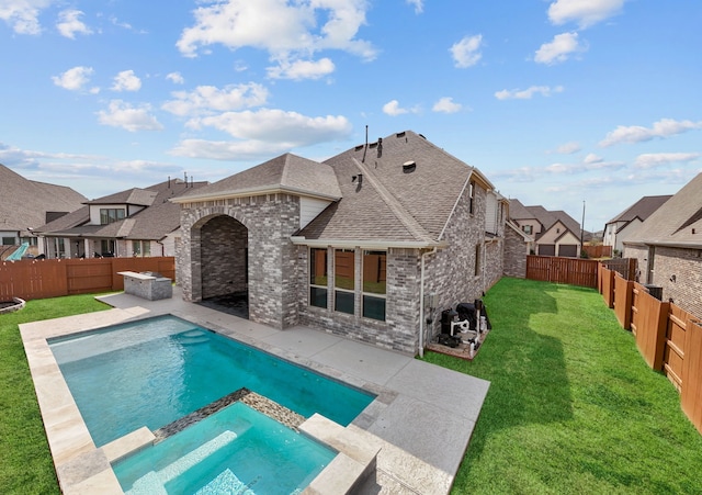 view of swimming pool featuring a yard, a patio, a fenced backyard, and a pool with connected hot tub