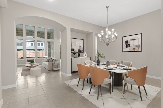 dining room featuring light tile patterned floors, baseboards, and an inviting chandelier