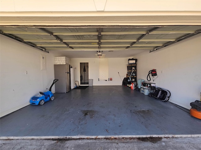 garage featuring a garage door opener and stainless steel refrigerator