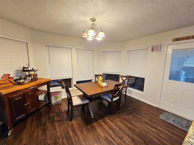 dining space with dark hardwood / wood-style floors, a textured ceiling, and a chandelier