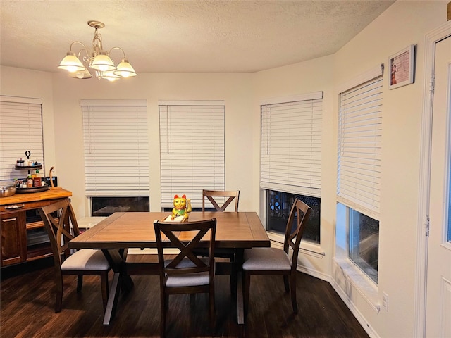 dining room with an inviting chandelier, dark hardwood / wood-style flooring, and a textured ceiling