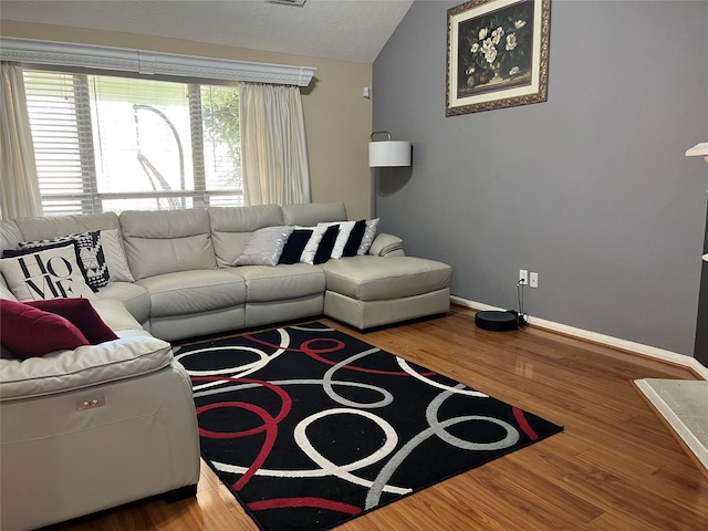 living room with vaulted ceiling, wood finished floors, and baseboards