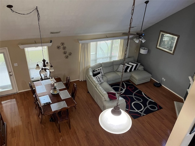 living room with vaulted ceiling, wood finished floors, visible vents, and baseboards