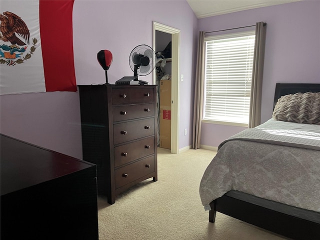 bedroom with light carpet, vaulted ceiling, and baseboards