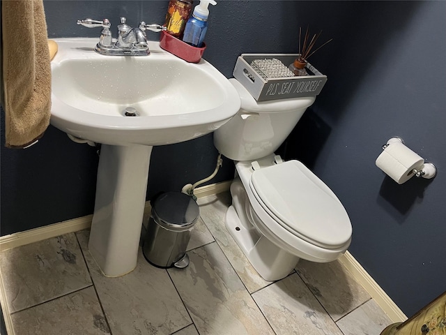bathroom with toilet and baseboards