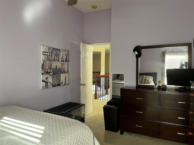 bedroom with light colored carpet and a towering ceiling