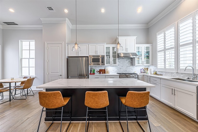 kitchen with appliances with stainless steel finishes, a center island, sink, and white cabinets