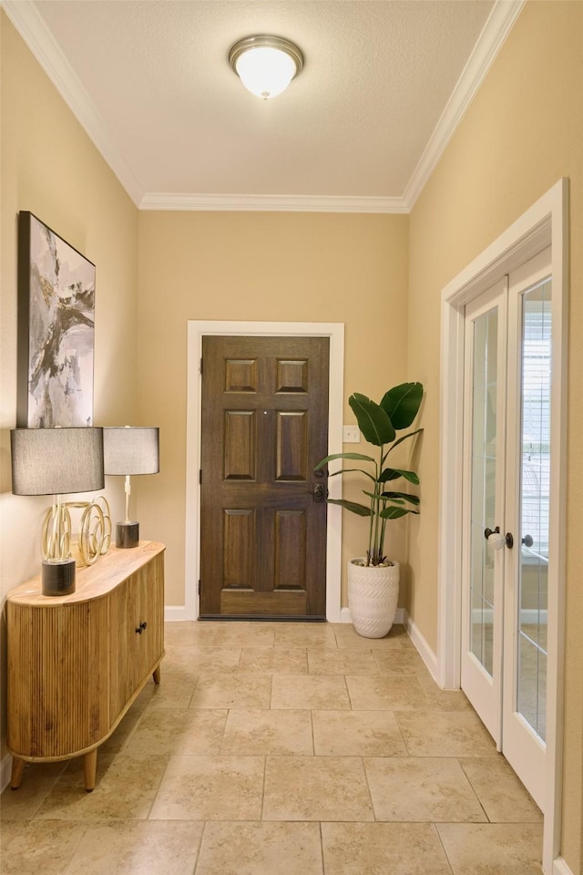 foyer entrance with ornamental molding and french doors
