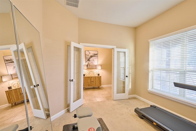 workout area featuring french doors and light colored carpet