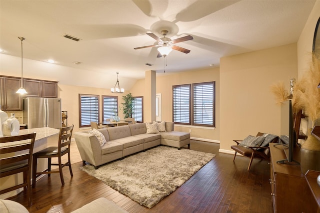 living room with lofted ceiling, dark hardwood / wood-style flooring, and ceiling fan with notable chandelier