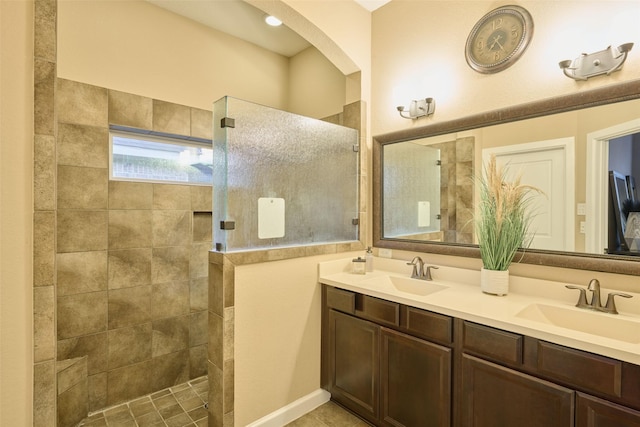 bathroom with vanity and tiled shower