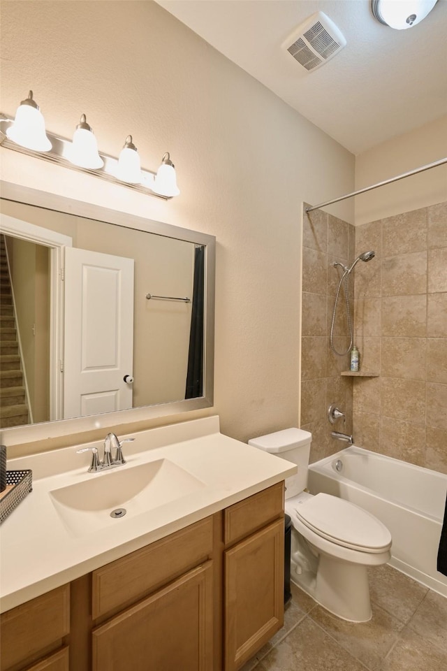 full bathroom featuring vanity, toilet, tiled shower / bath combo, and tile patterned flooring