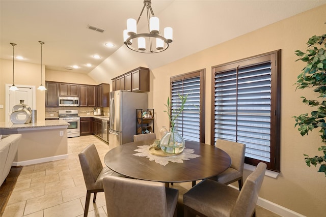 tiled dining space with vaulted ceiling and a notable chandelier