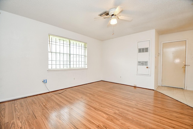 unfurnished room with ceiling fan, light hardwood / wood-style floors, and a textured ceiling