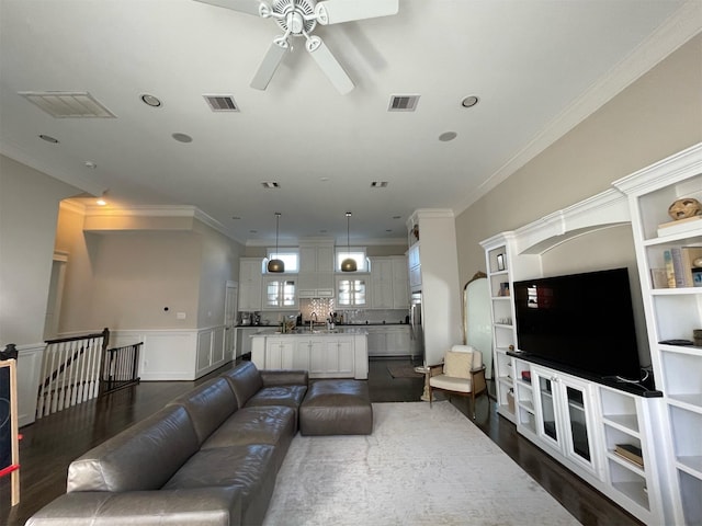 living room with ceiling fan, ornamental molding, and dark hardwood / wood-style flooring