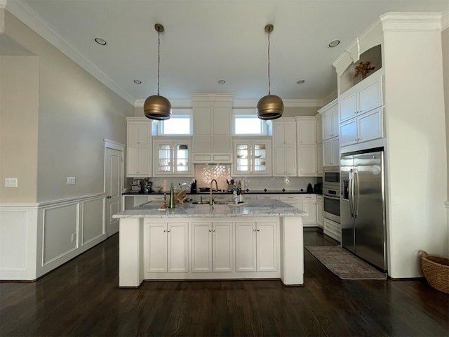 kitchen featuring hanging light fixtures, an island with sink, appliances with stainless steel finishes, and light stone counters