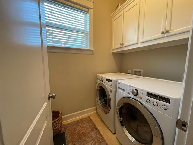 clothes washing area featuring cabinets, separate washer and dryer, and light tile patterned floors