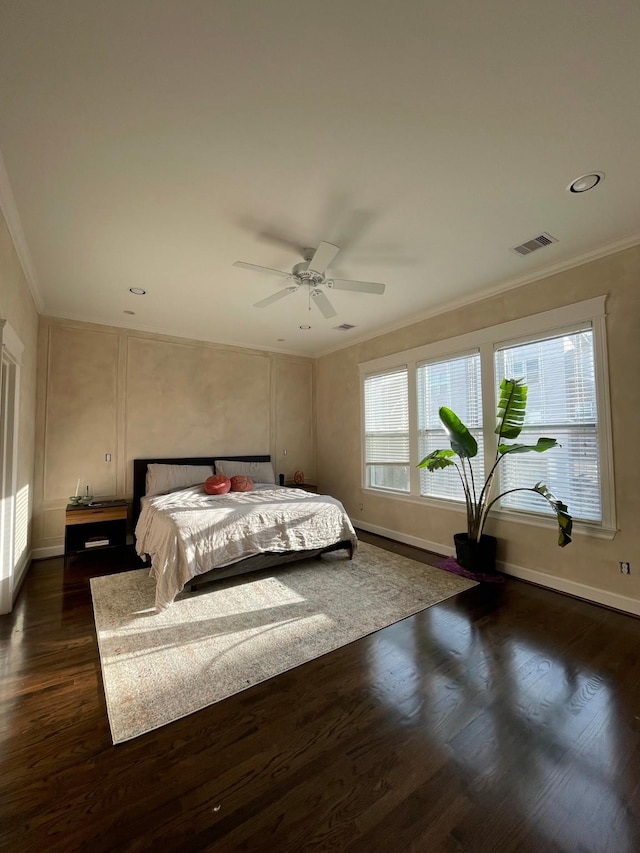 bedroom with dark wood-type flooring, ornamental molding, and ceiling fan