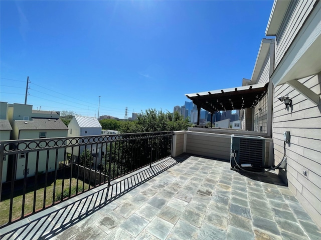 view of patio with a balcony and central air condition unit