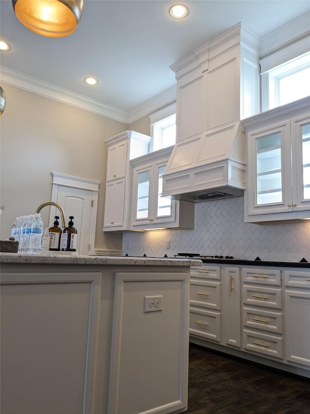 kitchen with white cabinetry, backsplash, and crown molding