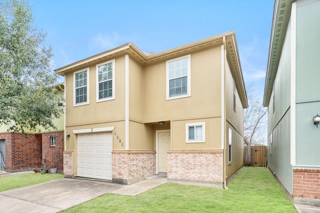 view of front facade featuring brick siding, a front yard, driveway, stucco siding, and a garage