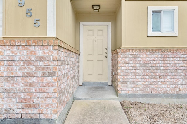 entrance to property featuring brick siding