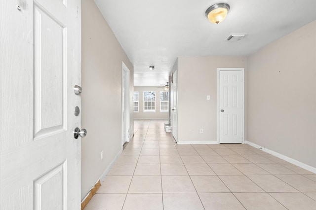 foyer with baseboards, visible vents, a ceiling fan, and light tile patterned floors