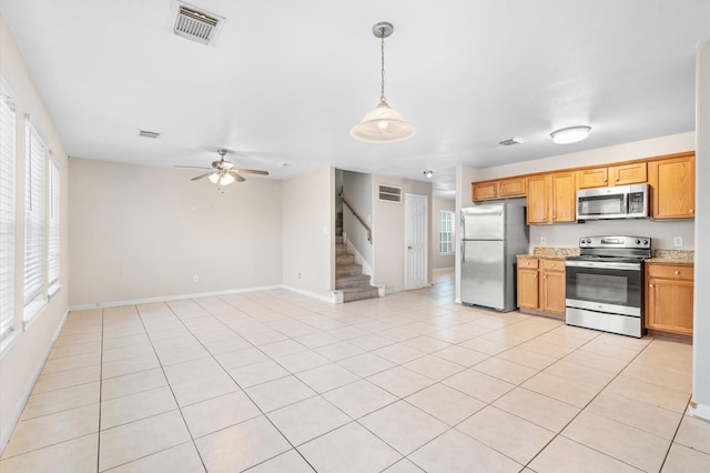 kitchen featuring hanging light fixtures, stainless steel appliances, visible vents, and light tile patterned flooring