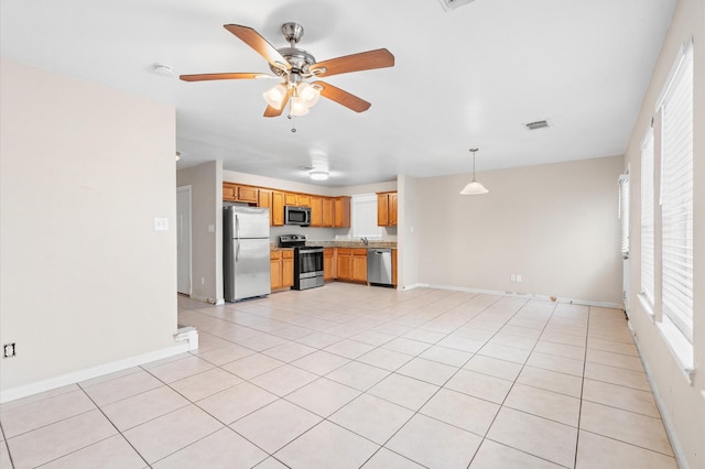 unfurnished living room with baseboards, ceiling fan, and light tile patterned flooring