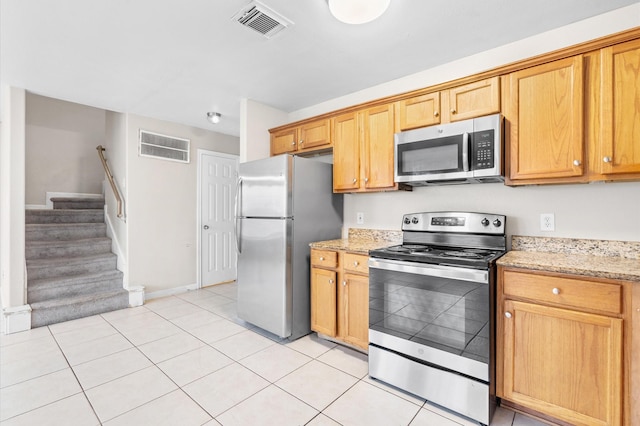 kitchen with visible vents, appliances with stainless steel finishes, light tile patterned flooring, and light stone countertops