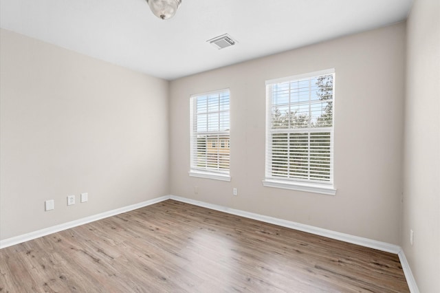 empty room with visible vents, baseboards, and light wood-type flooring