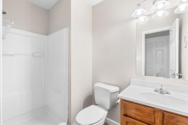 full bath featuring a stall shower, vanity, and toilet