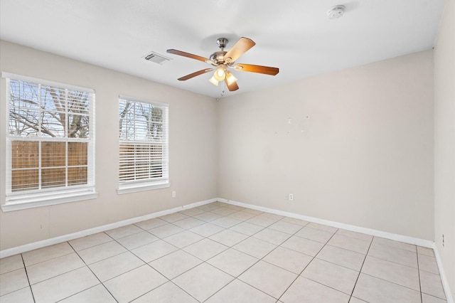 spare room with baseboards, ceiling fan, and visible vents