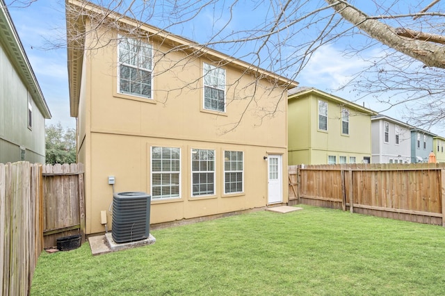 rear view of property featuring central AC, a yard, a fenced backyard, and stucco siding