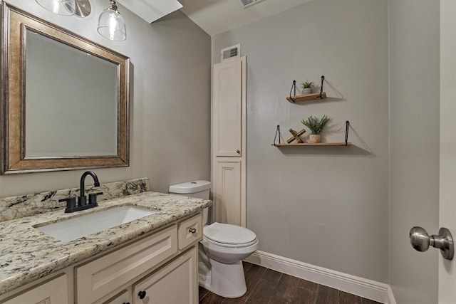 bathroom with vanity, hardwood / wood-style floors, and toilet