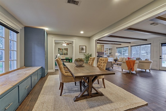 dining space featuring dark wood-type flooring and beamed ceiling