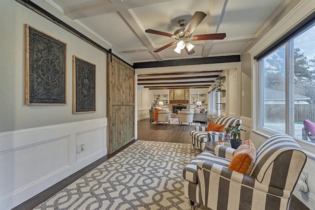 sitting room with coffered ceiling, beamed ceiling, dark hardwood / wood-style floors, and ceiling fan