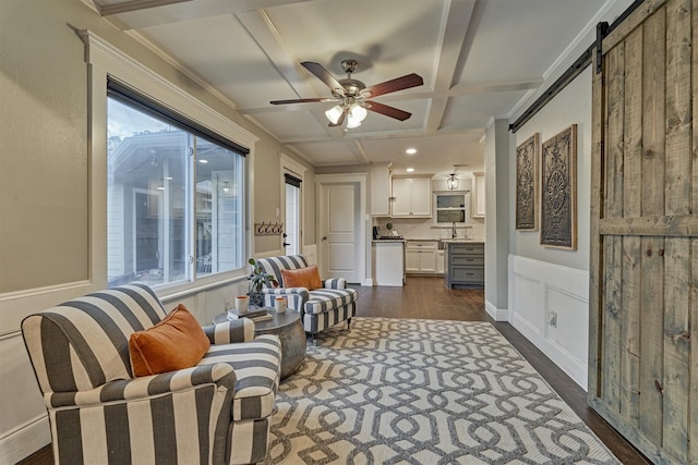 sitting room with coffered ceiling, sink, dark hardwood / wood-style floors, beamed ceiling, and a barn door