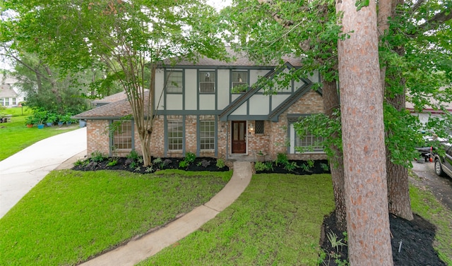 tudor-style house featuring a front lawn